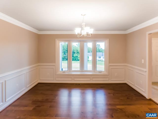 unfurnished room featuring dark hardwood / wood-style flooring, an inviting chandelier, and crown molding