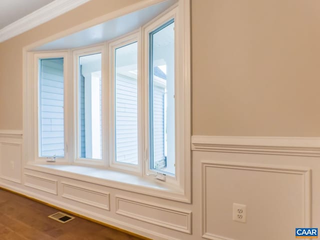 details with a tub, wood-type flooring, and ornamental molding