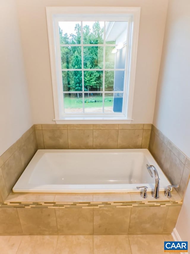 bathroom featuring a relaxing tiled bath and tile floors