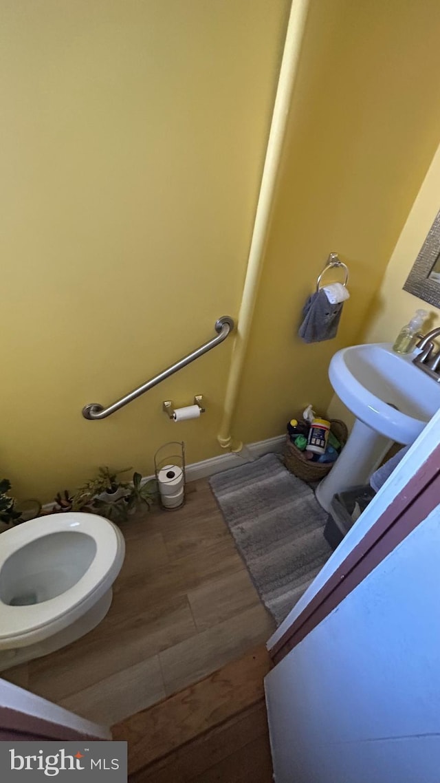 bathroom featuring sink, toilet, and hardwood / wood-style floors