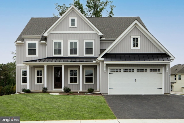 view of front facade with covered porch, a front yard, and a garage