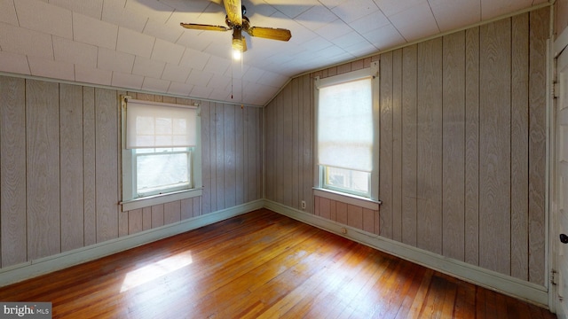 unfurnished room featuring light hardwood / wood-style flooring and wood walls