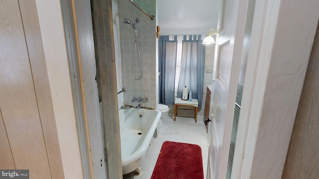 bathroom with tiled shower / bath combo and toilet