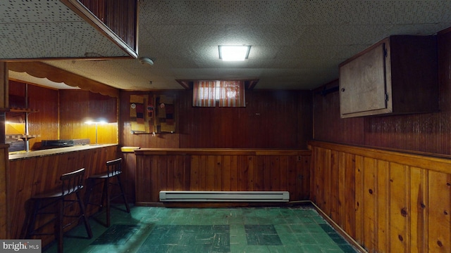 kitchen featuring wood walls and baseboard heating