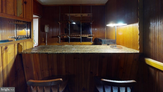 kitchen with a kitchen breakfast bar and stone counters