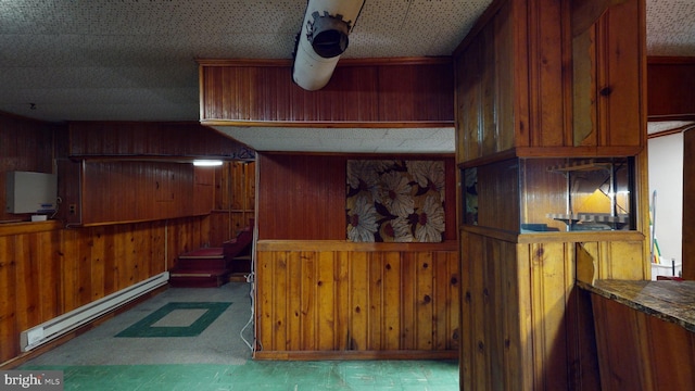 kitchen with wood walls and a baseboard heating unit