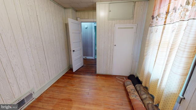 hallway with wooden walls and light hardwood / wood-style floors