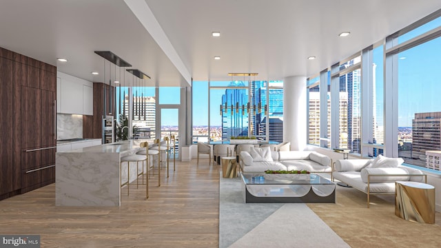 living room featuring light wood-type flooring, a water view, and plenty of natural light