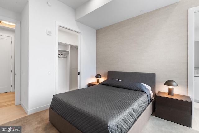 bedroom with wood-type flooring and a closet