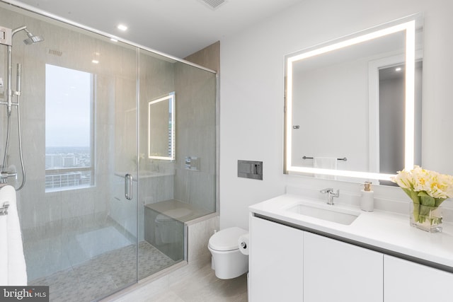 bathroom with a shower with shower door, vanity, and toilet