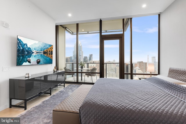 bedroom featuring floor to ceiling windows and light hardwood / wood-style floors