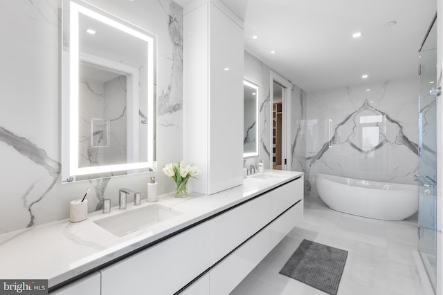 bathroom with tile walls, a bath, and vanity