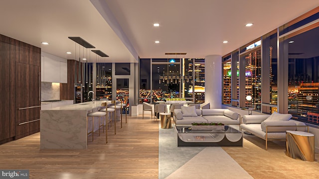 living room featuring expansive windows, indoor wet bar, and light wood-type flooring