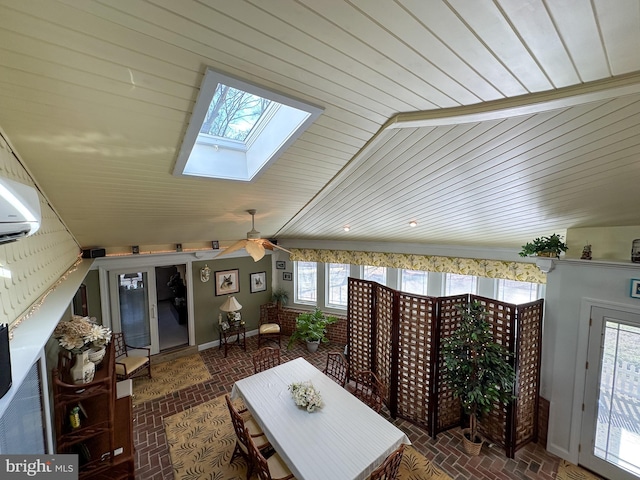 interior space featuring ceiling fan, a skylight, and a healthy amount of sunlight