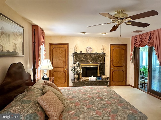 carpeted bedroom featuring ceiling fan, access to exterior, and a fireplace