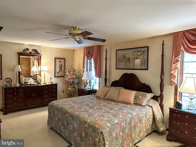 bedroom with light carpet, ceiling fan, and multiple windows