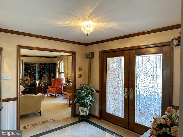 foyer featuring french doors, ornamental molding, and light tile flooring