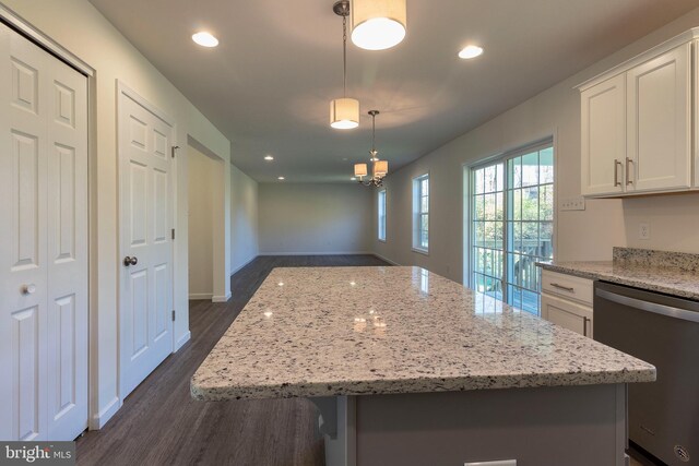 kitchen featuring hanging light fixtures, a kitchen island, stainless steel dishwasher, and white cabinets