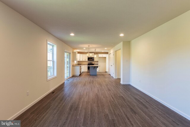 unfurnished living room featuring sink and dark hardwood / wood-style floors