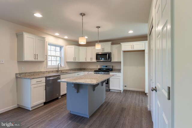 kitchen featuring sink, a center island, pendant lighting, stainless steel appliances, and white cabinets