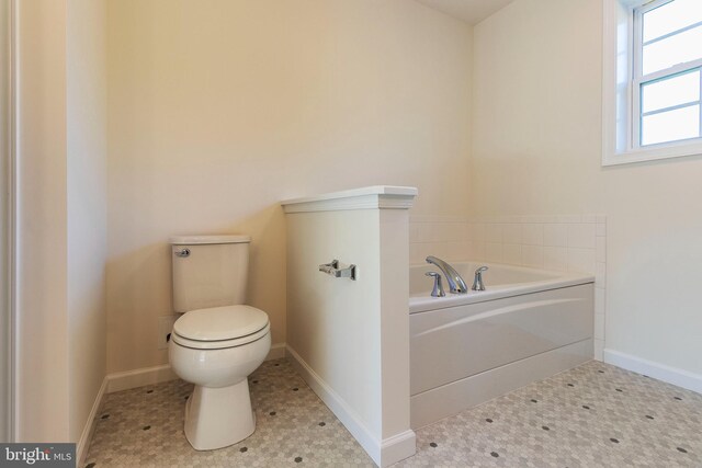 bathroom featuring tile patterned floors, a tub, and toilet