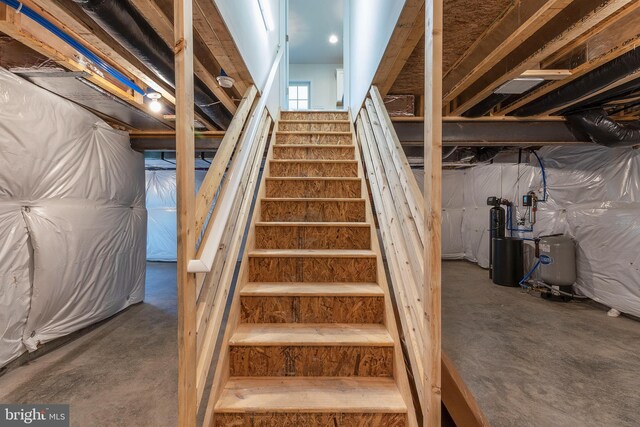 staircase featuring concrete floors