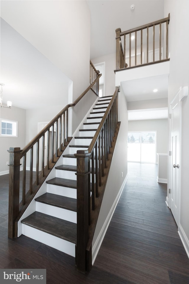 stairs featuring a high ceiling and hardwood / wood-style floors