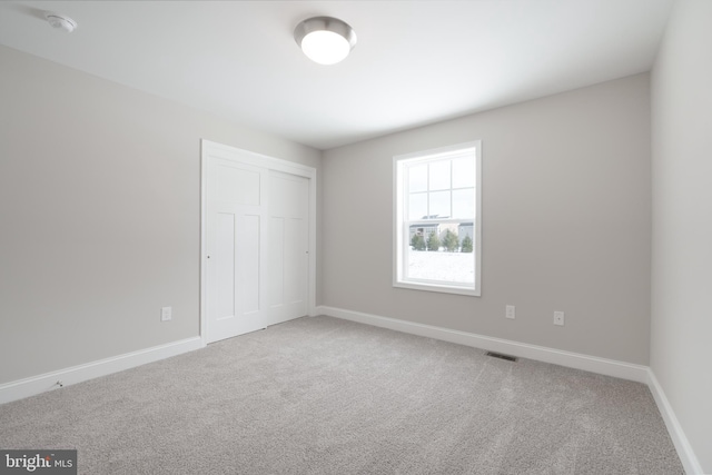 unfurnished bedroom featuring carpet and a closet