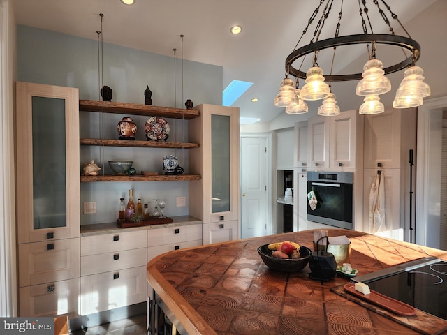 kitchen featuring lofted ceiling, dark hardwood / wood-style floors, stainless steel oven, and white cabinetry