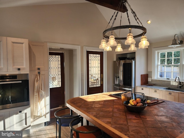 dining space with a chandelier, high vaulted ceiling, and sink