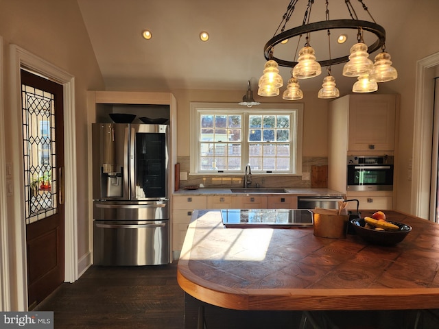 kitchen with stainless steel appliances, backsplash, sink, a chandelier, and dark hardwood / wood-style floors