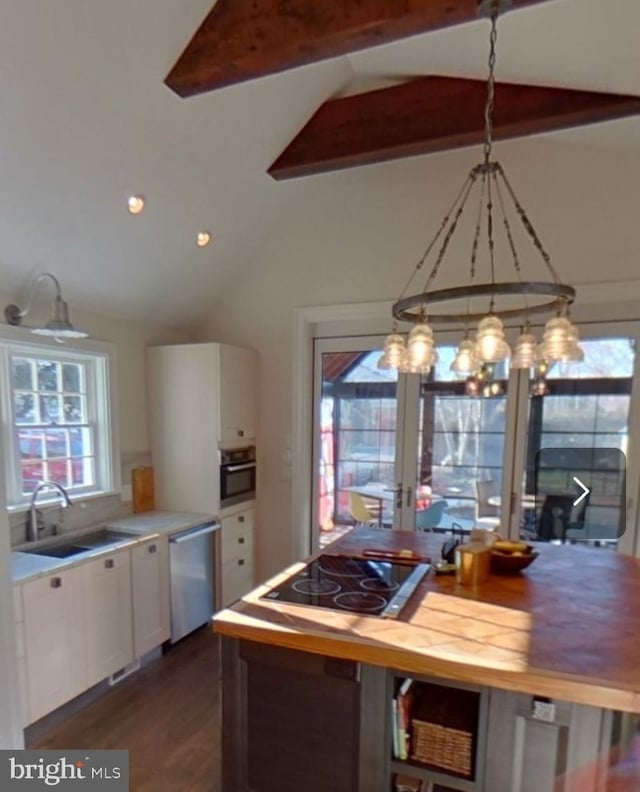 kitchen featuring pendant lighting, sink, white cabinets, a chandelier, and stainless steel appliances