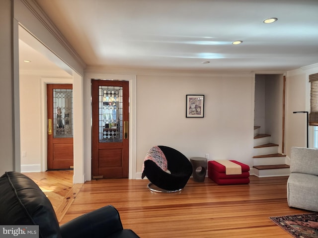 living room featuring crown molding and light hardwood / wood-style floors