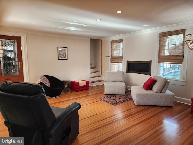 living room with crown molding and light hardwood / wood-style floors