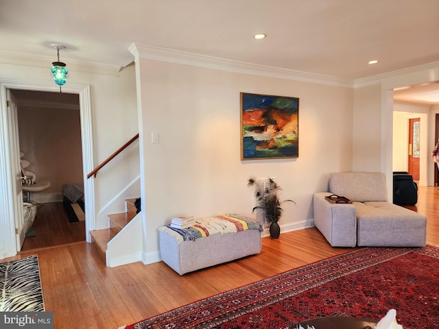 living room with crown molding and light hardwood / wood-style floors