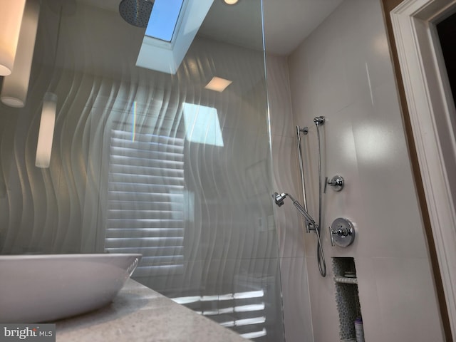 bathroom with walk in shower, vanity, and a skylight