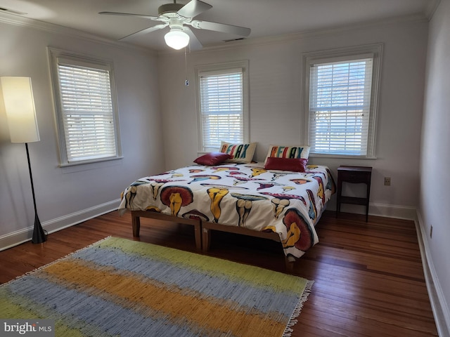 bedroom featuring dark hardwood / wood-style flooring, ceiling fan, and crown molding