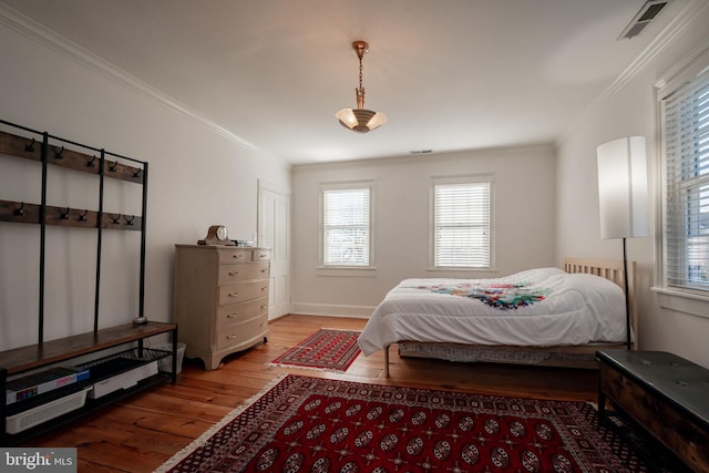 bedroom with ornamental molding and light hardwood / wood-style floors