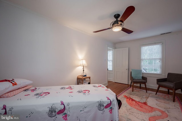 bedroom with ceiling fan, light wood-type flooring, and ornamental molding