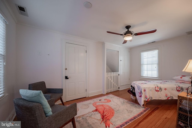 bedroom featuring ceiling fan, ornamental molding, and light hardwood / wood-style floors