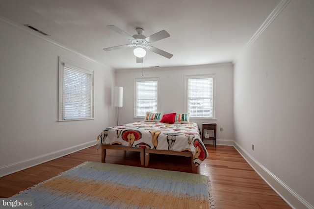 bedroom featuring ceiling fan, crown molding, and hardwood / wood-style floors