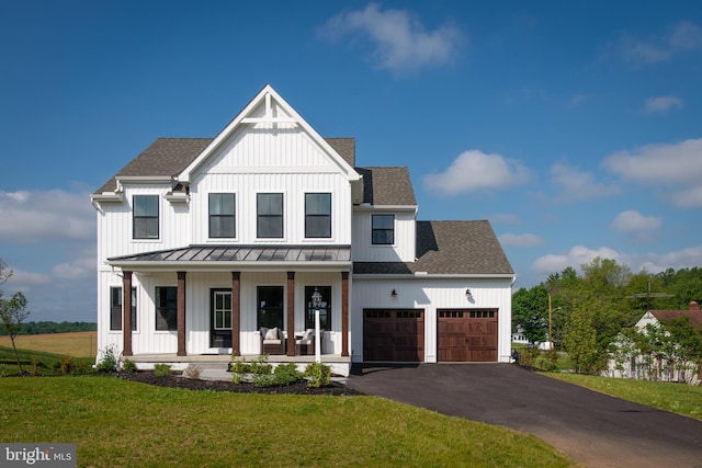 modern farmhouse style home with covered porch, a garage, and a front lawn