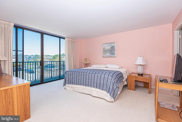 carpeted bedroom featuring access to outside and a wall of windows