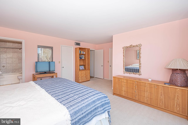 bedroom featuring light colored carpet and ensuite bathroom