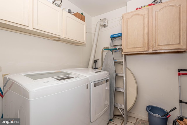 washroom featuring cabinets, independent washer and dryer, and light tile floors