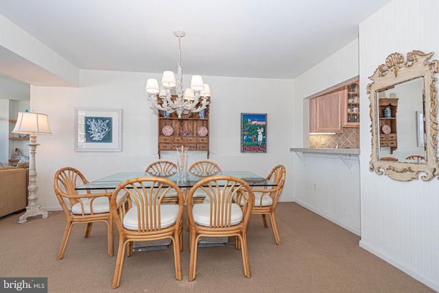 carpeted dining space featuring a chandelier