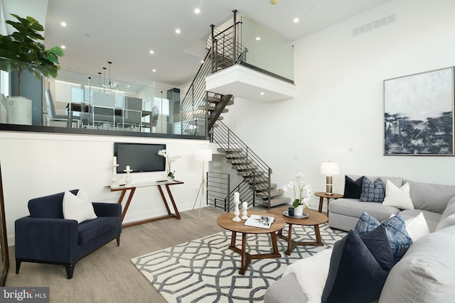 living room featuring light hardwood / wood-style floors and a high ceiling