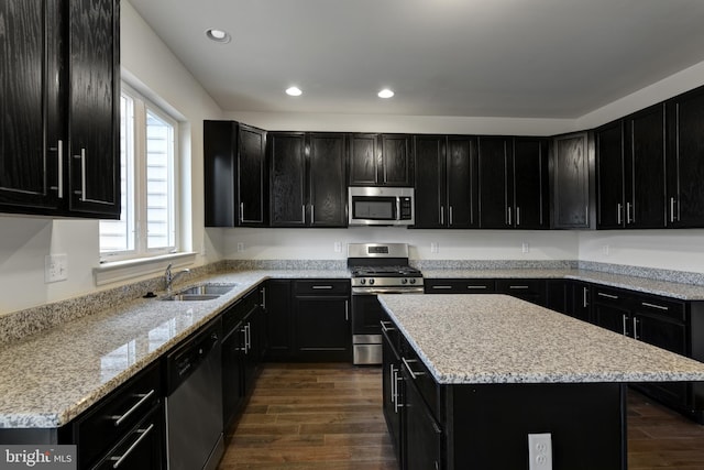 kitchen featuring dark hardwood / wood-style floors, stainless steel appliances, sink, and a center island