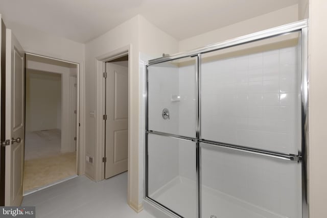 bathroom with tile floors and a shower with shower door