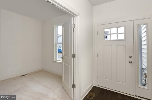 entrance foyer featuring plenty of natural light and light carpet